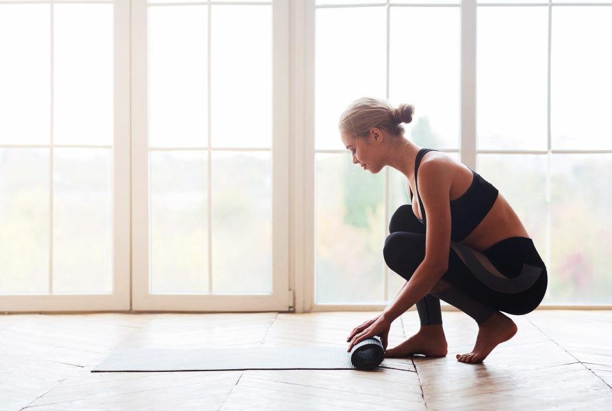 woman-after-practicing-yoga-rolling-yoga-mat-at-st-PK8LWUV-1.jpg